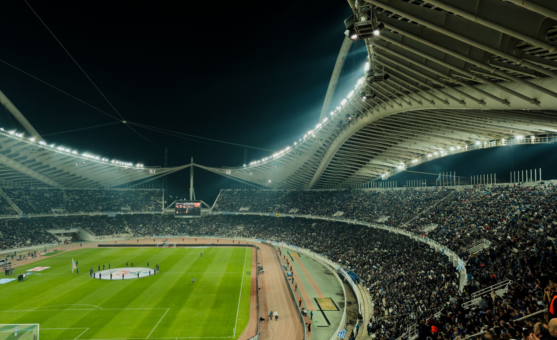 Estádio lotado durante partida noturna sob os refletores